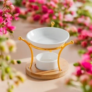 Brûle-parfum Etna élégant avec coupelle en céramique blanche, support doré incurvé et base ronde en bois.